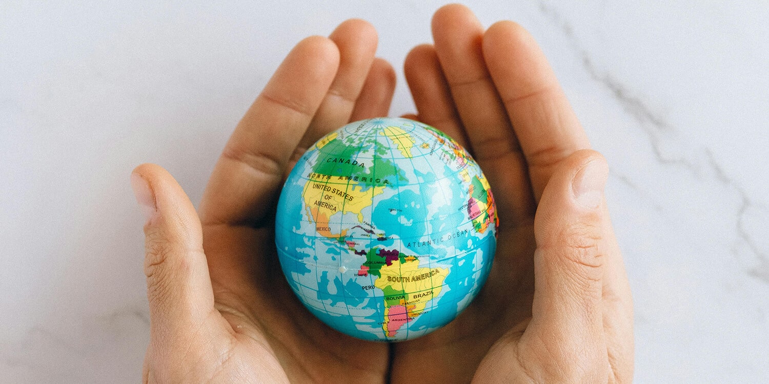 Hands holding a globe - where are you travelling?